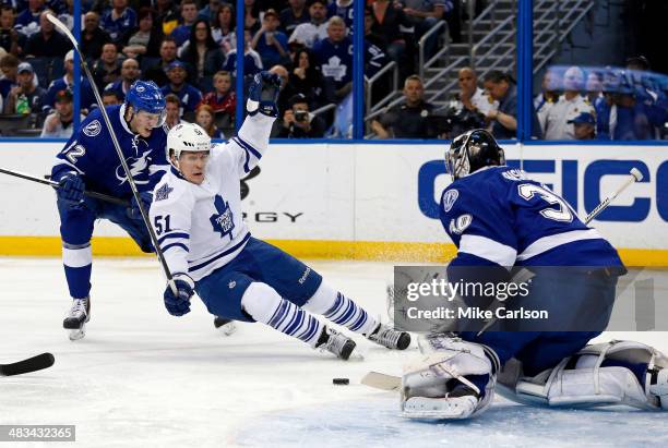 Andrej Sustr of the Tampa Bay Lightning checks Jake Gardiner of the Toronto Maple Leafs in front of goalie Ben Bishop at the Tampa Bay Times Forum on...