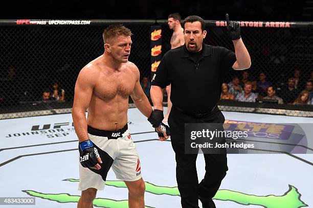 Referee John McCarthy takes a point away from Tom Watson of England after landing multiple strikes below the belt against Chris Camozzi in their...
