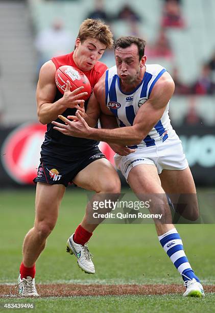 Jack Viney of the Demons is bumped by Todd Goldstein of the Kangaroos during the round 19 AFL match between the Melbourne Demons and the North...