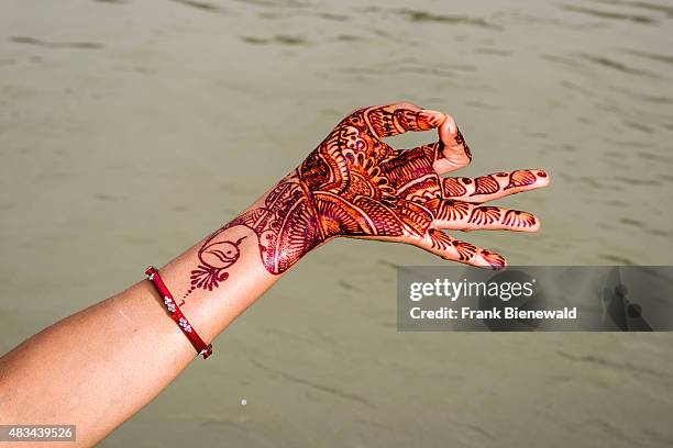 Henna painted hand is showing the mudra "Gyan Mudra" at the ghats of the holy river Ganges.