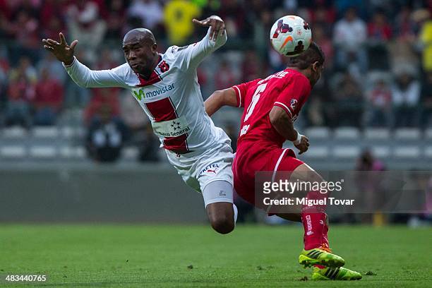 Miguel Ponce of Toluca fights for the ball with Jerry Palacios of Alajuelense during a semifinal match between Toluca and Alajuelense as part of the...