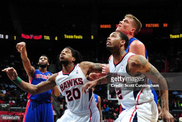 Cartier Martin and Mike Scott of the Atlanta Hawks box out Jonas Jerebko of the Detroit Pistons during the game on April 8, 2014 at Philips Arena in...