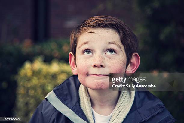happy smiling little boy looking up - boy thinking stockfoto's en -beelden