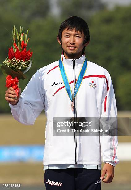 Bronze medallist Yasuhiro Suzuki of Japan celebrates on the podium at the medal ceremony for the Canoe Sprint Men's Kayak Single 1000m during day...