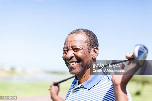 african senior golfer holding his club with a smile. - golf club 個照片及圖片檔