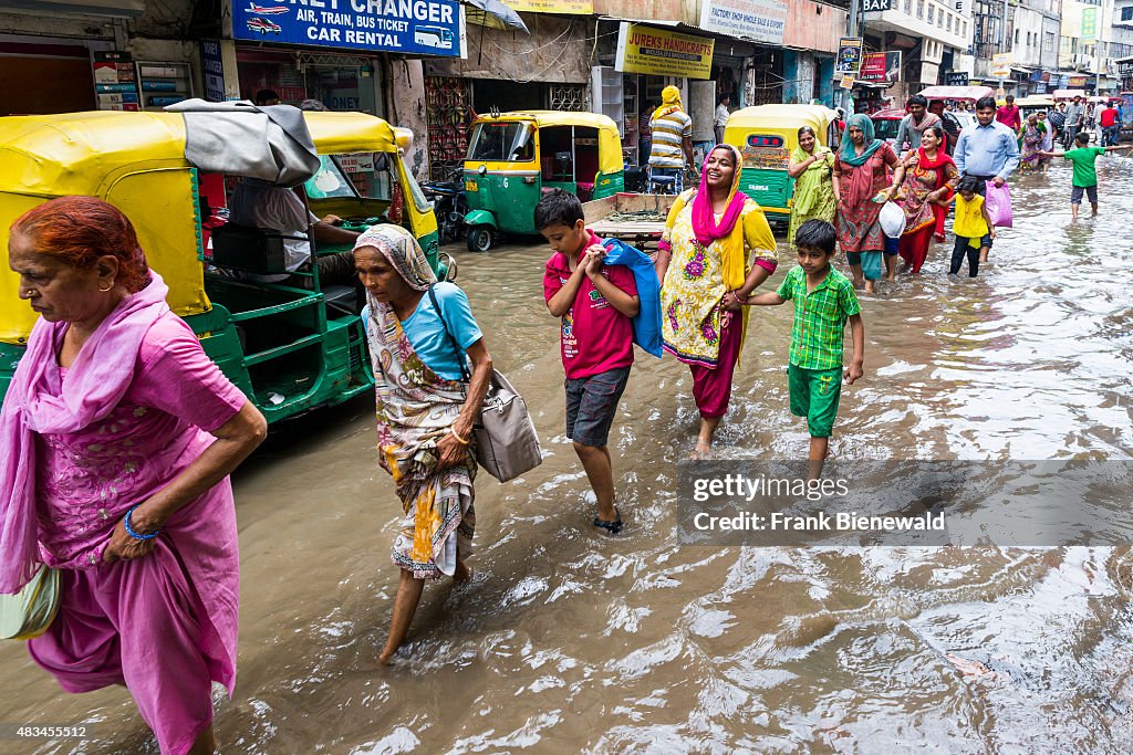 Many people and cycle rikshaws are moving through the...