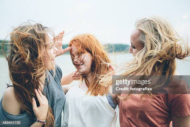 amitié: trois joyeux rire jeunes femmes s'amuser ensemble à l'extérieur - cheveux au vent photos et images de collection