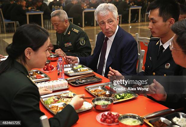 Secretary of Defense Chuck Hagel has lunch with students at the mess hall of the Non-Commissioned Officer Academy during a tour April 9, 2014 in...