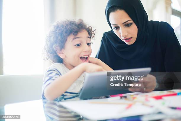 middle eastern mother helping her child with homework. - learn arabic stockfoto's en -beelden