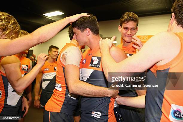 Jonathon Patton of the Giants is congratulated by team mates after winning his first game back from injury in the round 19 AFL match between the...