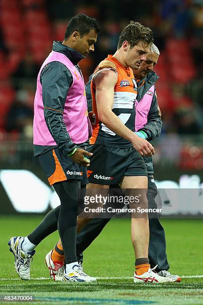 Stephen Coniglio of the Giants leaves the field after receiving a head knock during the round 19 AFL match between the Greater Western Sydney Giants...