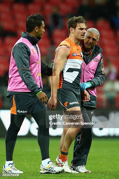 Stephen Coniglio of the Giants leaves the field after receiving a head knock during the round 19 AFL match between the Greater Western Sydney Giants...