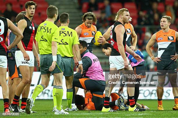 Adam Cooney of the Bombers walks past Stephen Coniglio of the Giants after colliding with him during the round 19 AFL match between the Greater...