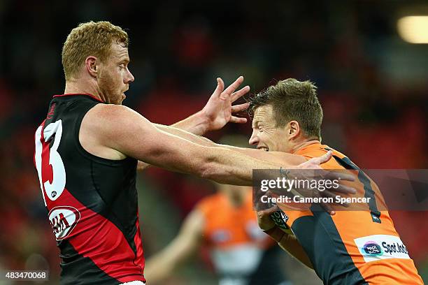 Rhys Palmer of the Giants fends off Adam Cooney of the Bombers during the round 19 AFL match between the Greater Western Sydney Giants and the...