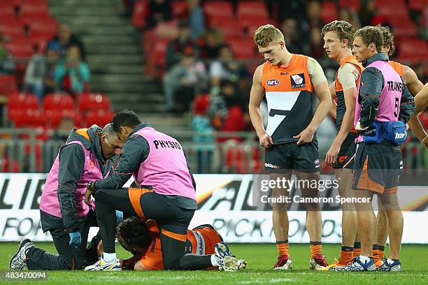 Stephen Coniglio of the Giants receives attention during the round 19 AFL match between the Greater Western Sydney Giants and the Essendon Bombers at...