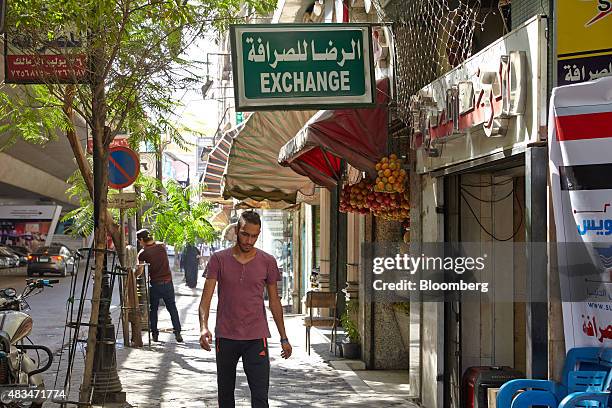 Man walks past a foreign currency exchange bureau on a street in Cairo, Egypt, on Friday, Aug. 7, 2015. The Suez canal extension and other...