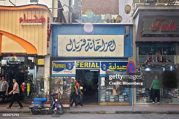 Pedestrians walk past stores on a street in Cairo, Egypt, on Friday, Aug. 7, 2015. The Suez canal extension and other construction projects have...