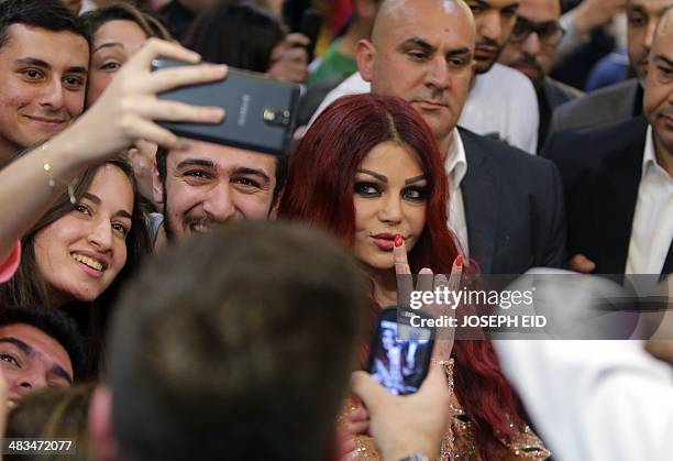 Lebanese pop star Haifa Wehbe poses for pictures with her fans as she arrives for the Premiere of he movie 'Halawet Rooh' at a movie theatre in the...