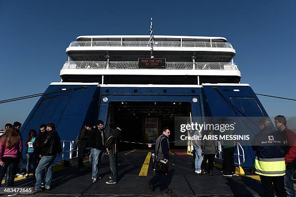 People stand outside a docked ferry at the port of Piraeus during a 24-hour general strike in Athens on April 9, 2014. The boards of the General...