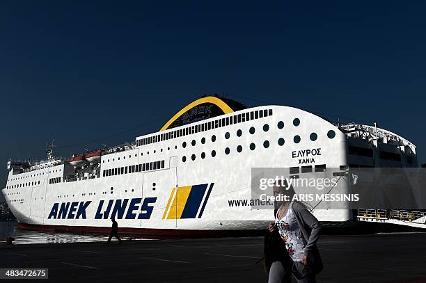 Woman passes by a docked ferry at the port of Piraeus during a 24-hour general strike in Athens on April 9, 2014. The boards of the General...