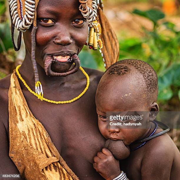 授乳からマーシ族の女性彼女のベビー、エチオピア、アフリカ - アフリカ 原住民 ストックフォトと画像
