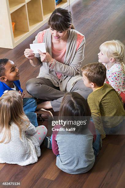 teacher and preschoolers sitting on floor in circle - children circle floor stock pictures, royalty-free photos & images