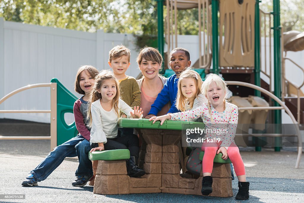 Gruppe von preschoolers mit Lehrer auf Spielplatz Tisch