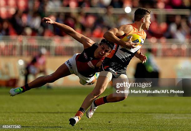 Josh Kelly of the Giants evades the tackle of Mark Baguley of the Bombers during the round 19 AFL match between the Greater Western Sydney Giants and...