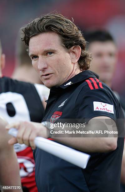 Bombers head coach James Hird talks to players during the round 19 AFL match between the Greater Western Sydney Giants and the Essendon Bombers at...