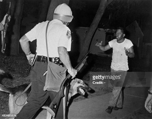 Helmeted police riot argue with an African american man as Newark witnessed its second night of rioting on July 14, 1967.