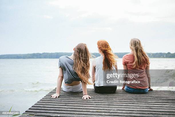 rear view of three teenage girls with blowing long hair - lake auburn stock pictures, royalty-free photos & images