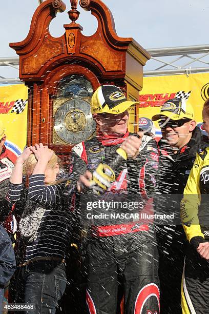 Kurt Busch, driver of the Haas Automation Chevy SS, celebrates with champagne in victory lane after winning the STP Gas Booster 500 at the...