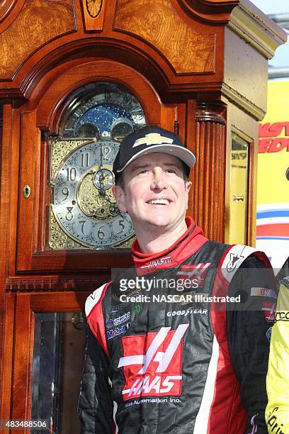 Kurt Busch, driver of the Haas Automation Chevy SS, poses for a picture with his grandfather clock trophy in victory lane after winning the STP Gas...