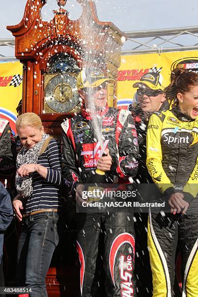 Kurt Busch, driver of the Haas Automation Chevy SS, celebrates with champagne in victory lane after winning the STP Gas Booster 500 at the...