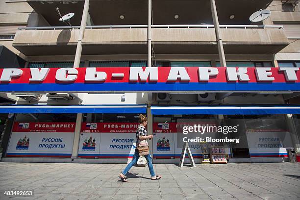 Pedestrian passes a Russian supermarket, branded in the colors of the Russian Federation, in Limassol, Cyprus, on Tuesday, April 8, 2014. Cyprus...