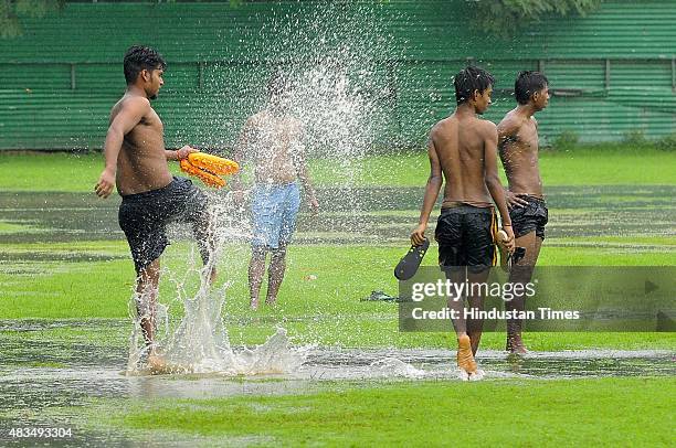 People enjoy during pleasant weather rainfall on August 9, 2015 in Noida, India. Heavy rains caused major waterlogging in many areas, leaving...