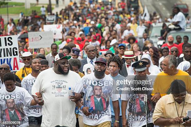 Michael Brown Sr. Leads a march from the location where his son Michael Brown Jr. Was shot and killed following a memorial service marking the...