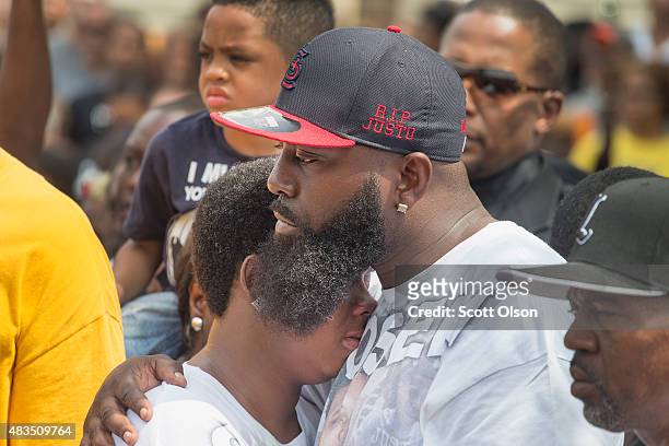 Michael Brown Sr. Comforts his wife Cal Brown during a moment of silence in the center of Canfield Street, where Michael Brown Jr. Was killed, during...