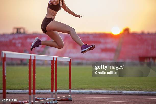 athlet frau hürdenlauf - hurdles stock-fotos und bilder