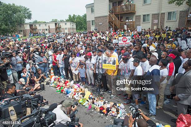 People attend a memorial service to mark the anniversary of Michael Brown's death on August 9, 2015 in Ferguson, Missouri. Brown was shot and killed...