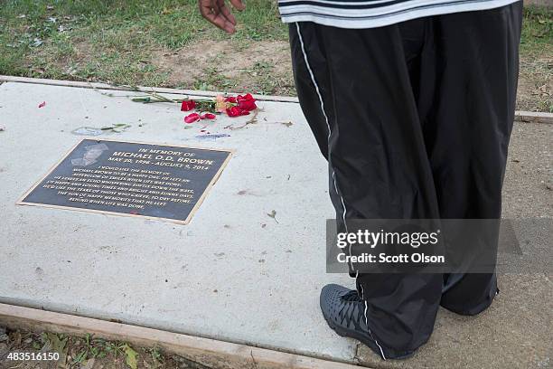 Man pauses at a plaque in the sidewalk which honors Michael Brown following a memorial service marking the anniversary of Brown's death on August 9,...