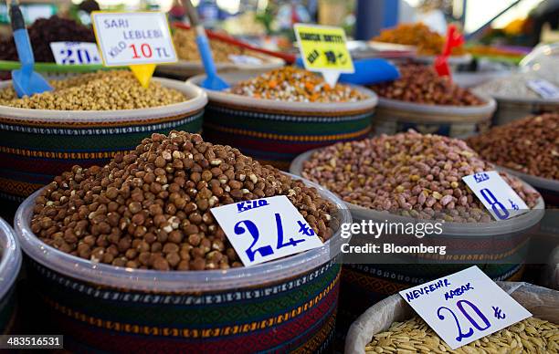 Lira price signs sit on tubs of nuts for sale at a stall in the Yesilkoy street market in Istanbul, Turkey, on Wednesday, April 9, 2014. Turkish...