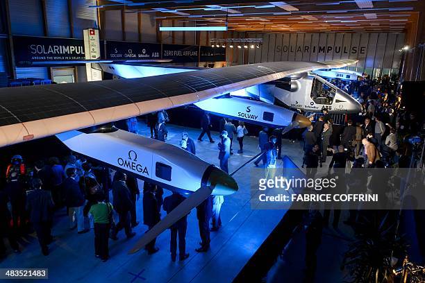 People look at the second Solar Impulse experimental solar-powered plane, the HB-SIB, to be used for a round-the-world voyage next year, during its...