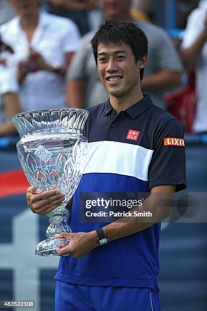 Kei Nishikori of Japan celebrates with the trophy after defeating John Isner of the United States in the men's singles final during the Citi Open at...