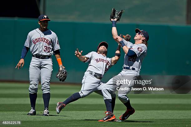 Jose Altuve of the Houston Astros collides with Colby Rasmus in front of Carlos Gomez as Rasmus catches a fly ball hit off the bat of Brett Lawrie of...