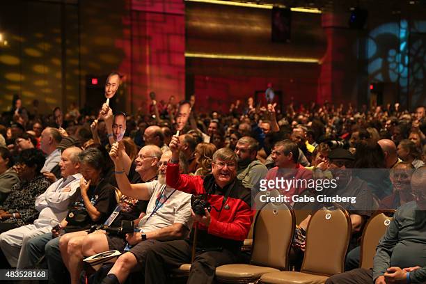 Attendees wave cardboard cutouts of actor George Takei as he speaks during the 14th annual official Star Trek convention at the Rio Hotel & Casino on...
