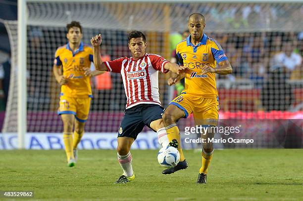 Michael Perez of Chivas fights for the ball with Guido Pizarro of Tigres during a 3rd round match between Tigres UANL and Chivas as part of the...