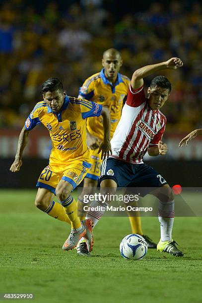 Javier Aquino of Tigres fights for the ball with Michael Perez of Chivas during a 3rd round match between Tigres UANL and Chivas as part of the...