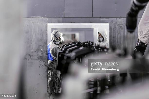 Employees add the final touches to tool boxes for the Royal Enfield Motors Ltd. Classic 350 motorcycle moving on a conveyor on the production line at...