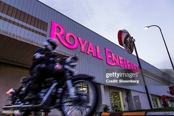 Motorcyclist rides past a Royal Enfield Motors Ltd. Manufacturing facility in Chennai, India, on Tuesday, July 14, 2015. In a sweltering factory in...